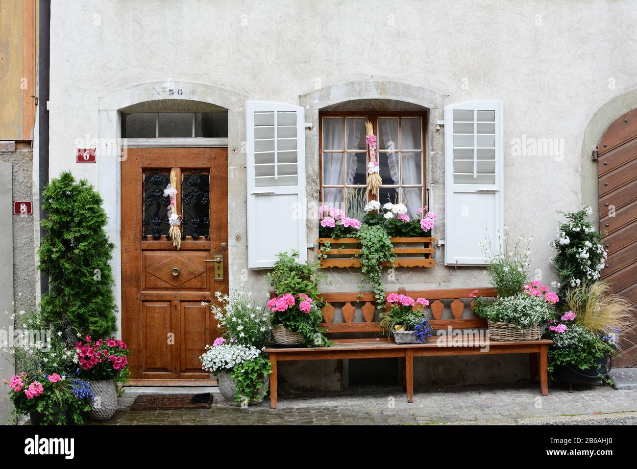 Gruyeres, SCHWEIZ - 8. JULI 2014: Haustür zum Schweizer Traditionshaus. Das malerische Haus liegt an der Kopfsteinpflaster Hauptstraße in der Altstadt von Gruyer Stockfoto