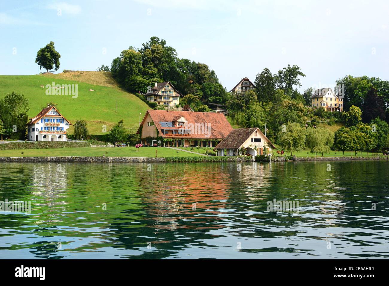 VIERWALDSTÄTTERSEE, SCHWEIZ - 4. JULI 2014: Wohnungen und Bauernhöfe am Vierwaldstättersee, Schweiz. Der See ist der viertgrößte des Landes. Stockfoto