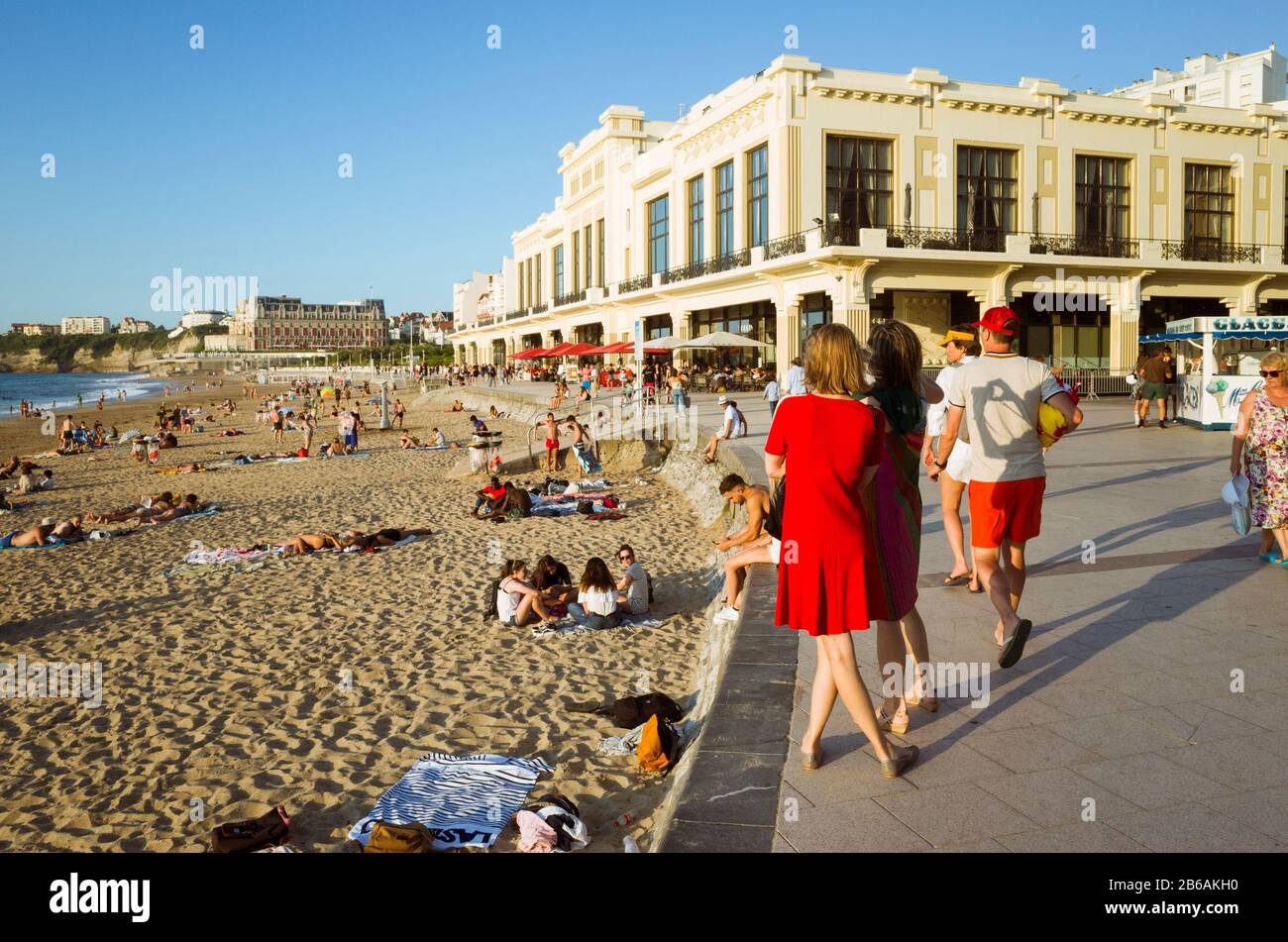 Biarritz, französisches Baskenland, Frankreich - 19. Juli 2019: Zwei Frauen sehen sich La Grande Plage an, den größten Strand der Stadt mit dem Art Deco Casino von Bi Stockfoto
