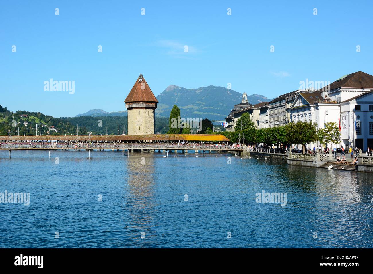 Luzerne, SCHWEIZ - 3. JULI 2014: Kapellenbrücke am Fluss Reuss. Berge, Hotels und der Bahnhof stehen im Hintergrund. Stockfoto