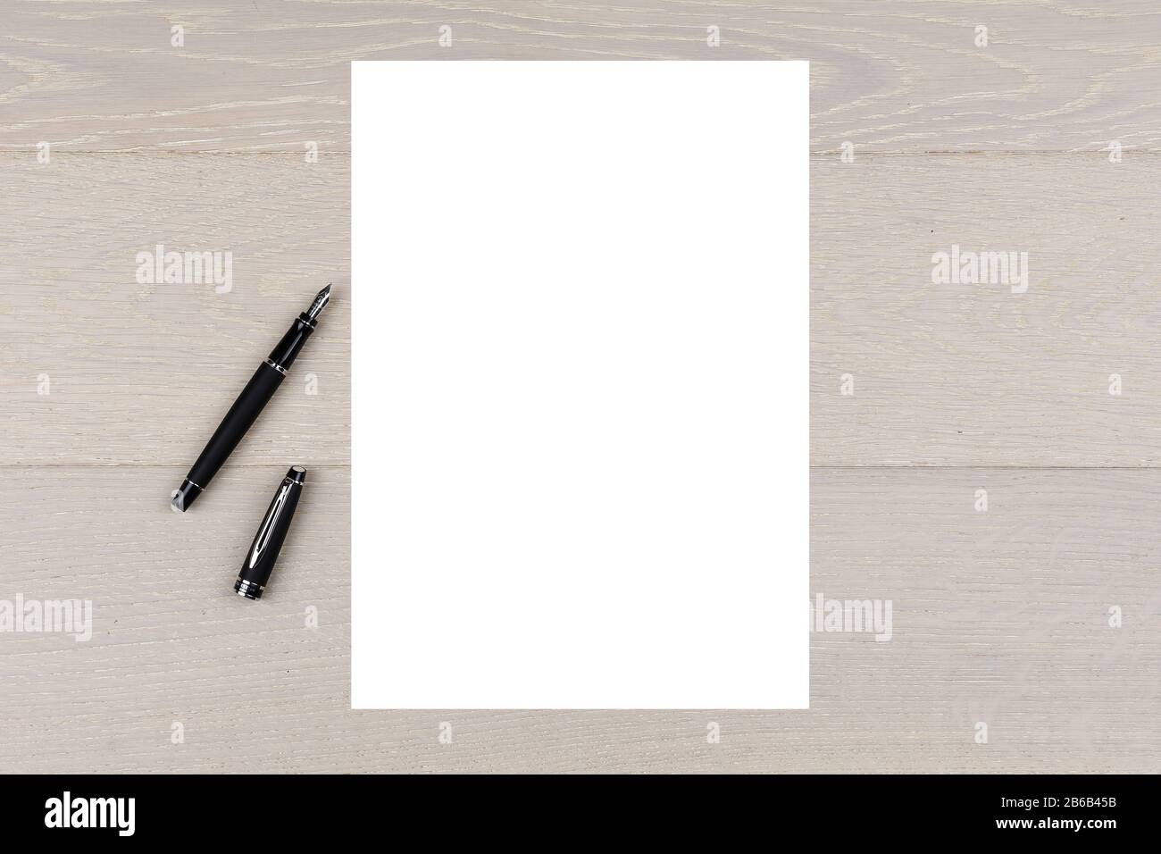 A4-Whitepaper auf hellem Holz mit Farbfontinen-Stift-Kopierbereich Stockfoto