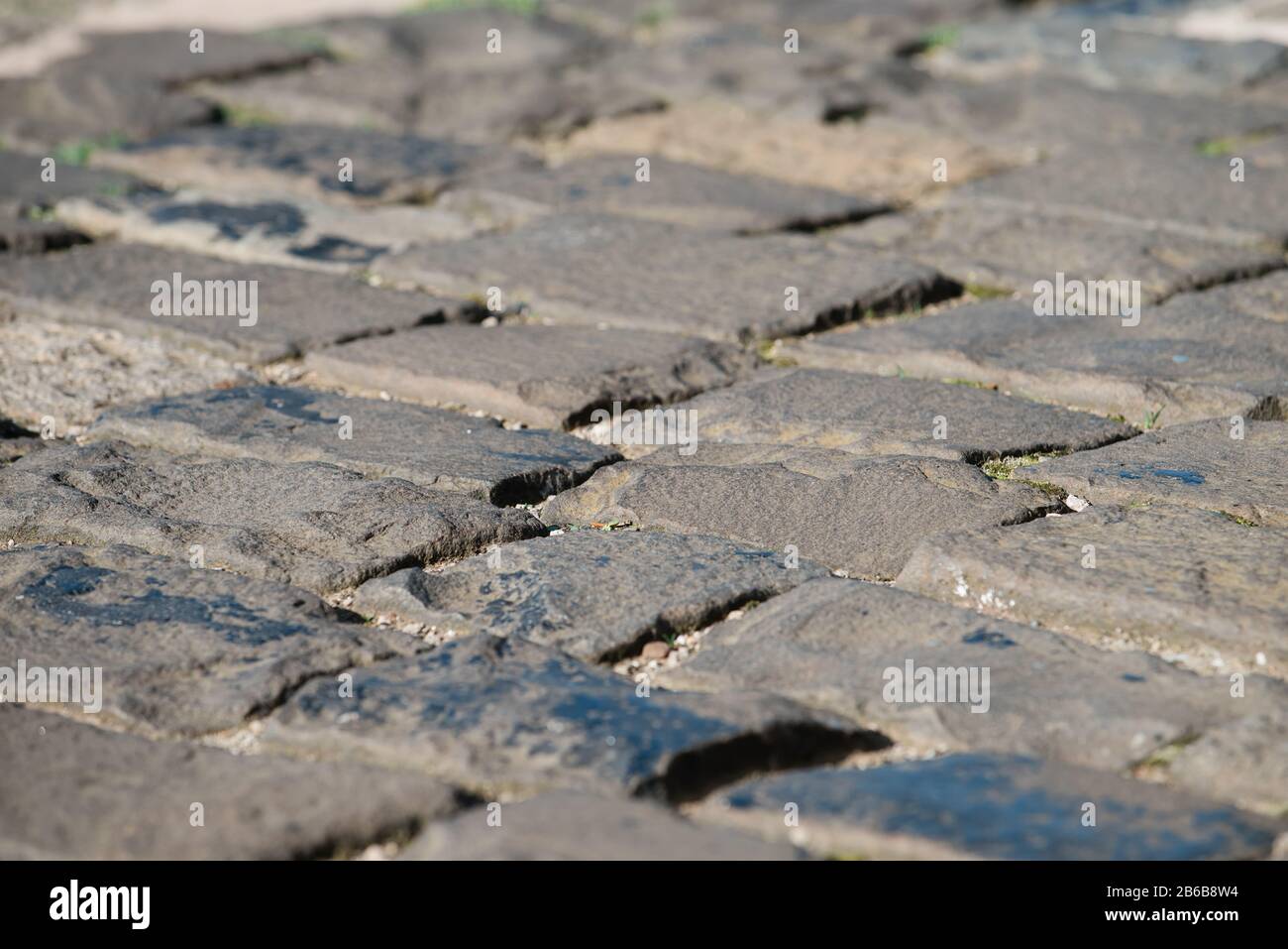 Nahaufnahme einer alten Kopfsteinpflaster-/Pflasterstraße, Hintergrund Stockfoto