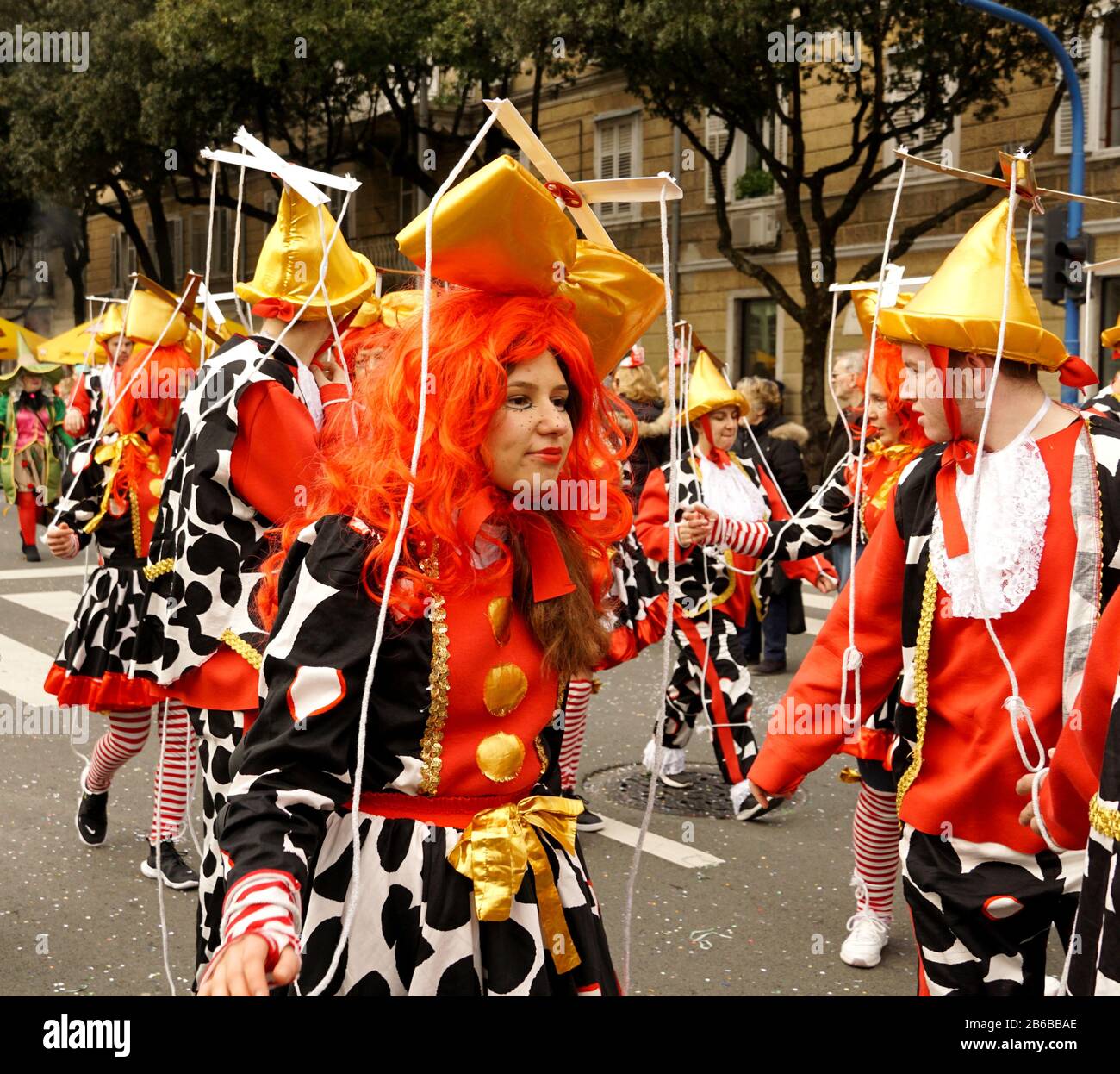 Rijeka, Kroatien, 23. Februar 2020. Marionette auf der Straße. Lustige Mädchen mit roter Perücke in Puppentracht auf einem Karnevalsumzug Stockfoto