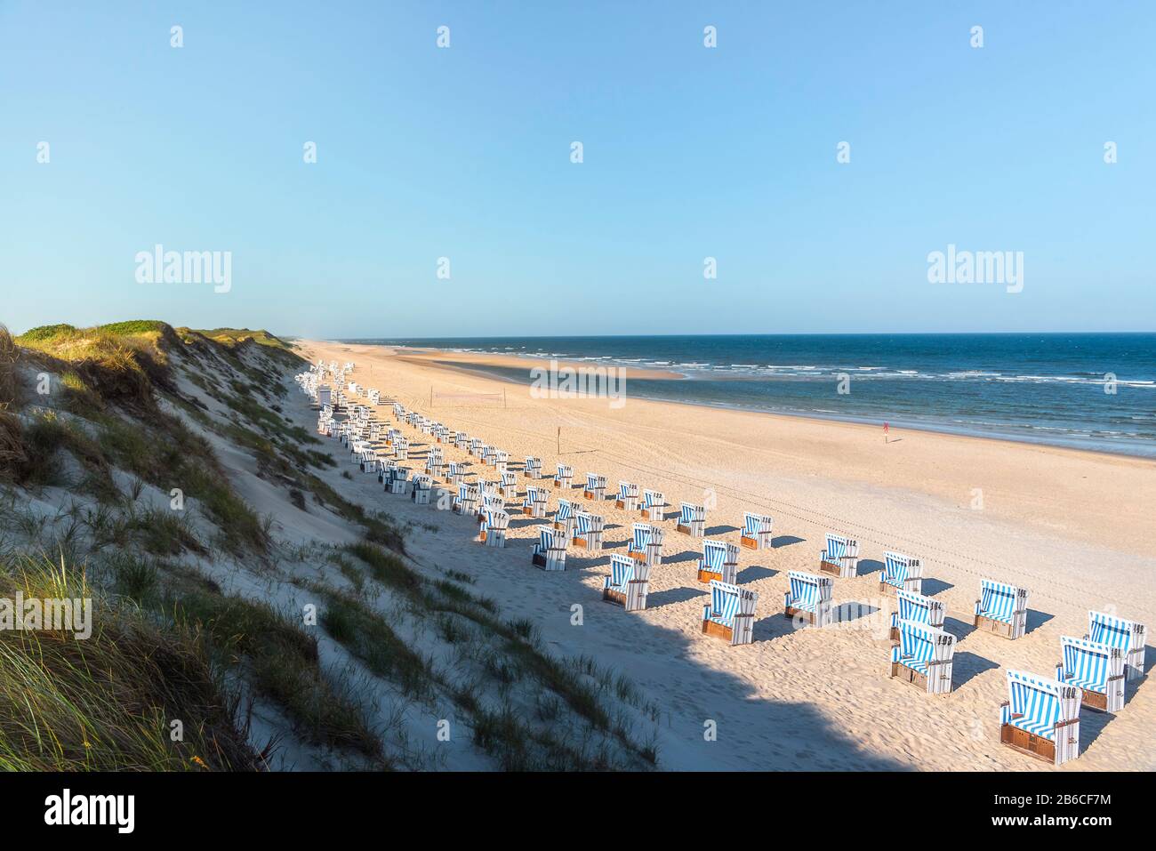 Sommerlandschaft mit Strand auf der abgelegenen Sylt Insel an der Nordsee, Deutschland. Korbstühle hintereinander am Strand ausgerichtet. Stockfoto