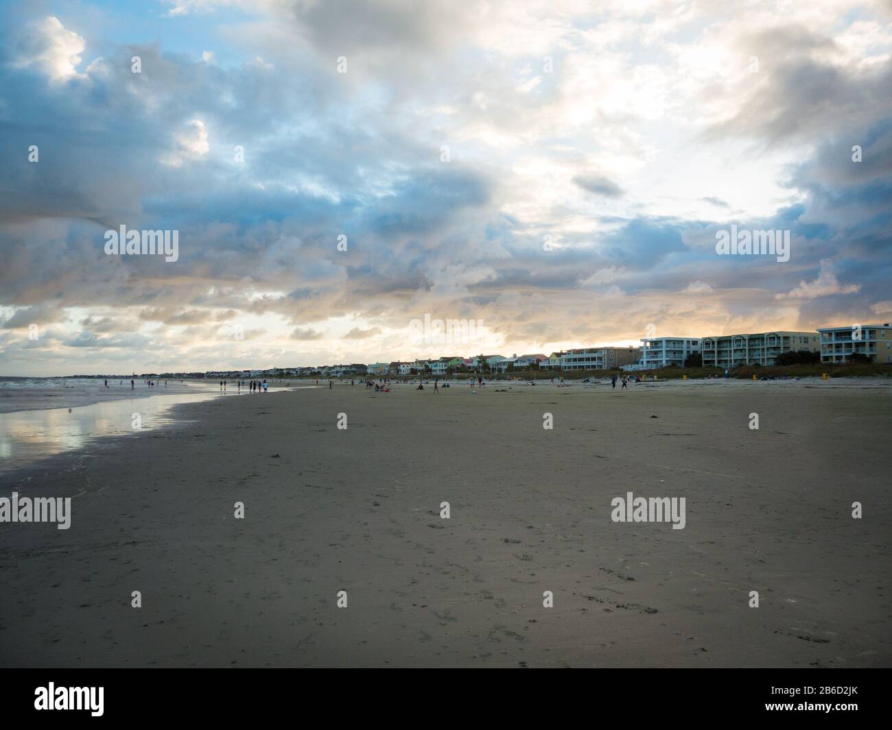 Dramatische Wolkenlandschaft mit Sonneneinstrahlung über dem lebhaften Tybee Island Beach, Georgia. Bunte Wolken mit fast leerem Strand. Stockfoto