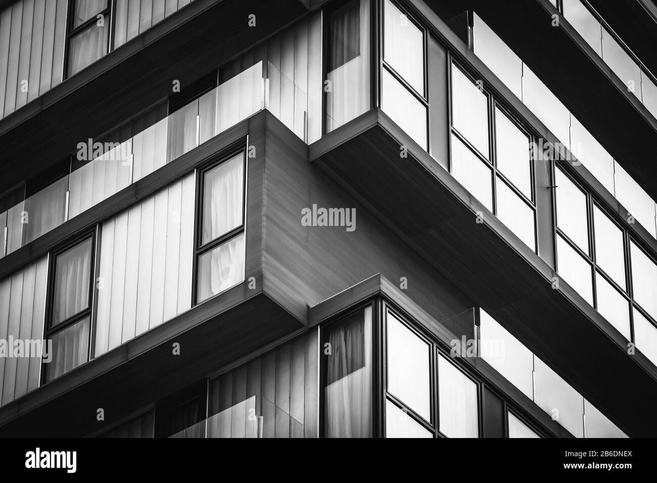 Detail der gläsernen Balkone eines minimalistischen Stadtgebäudes - Schwarz und Weiß Stockfoto