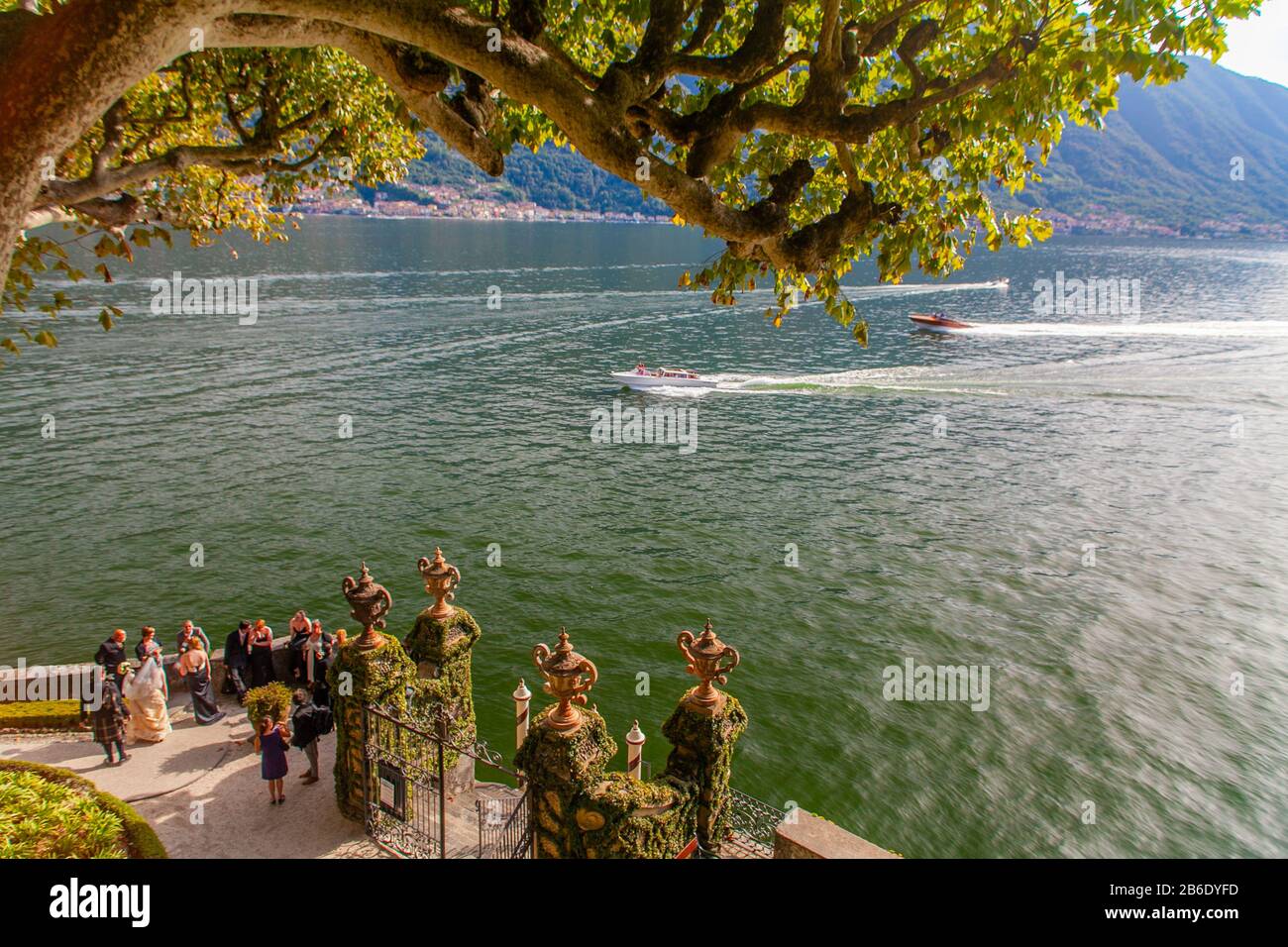 Menschen, die bei Sonnenuntergang eine Hochzeitsfeier in der Villa del Balbianello am Comer See, Lombardei, Italien, feiern Stockfoto