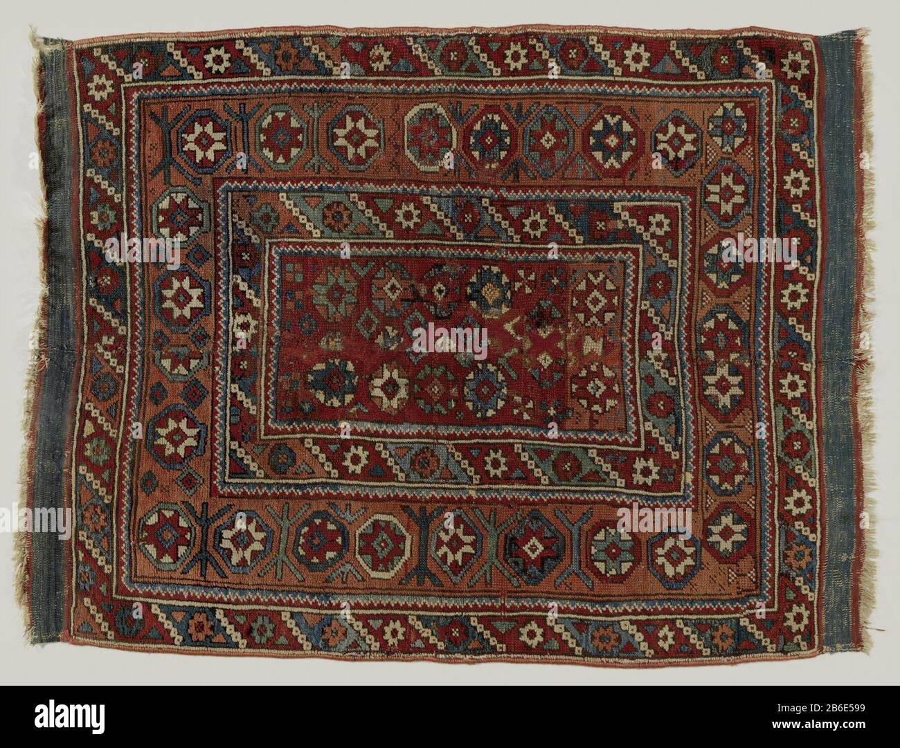 Blumenkleid Bloemenkleed. Middenveld: OP een klein donkerrood veld staan sterbloemen in een dubbele baan. OM elke sterbloem een achthoekje in wit, rood, lichtgroen en blauw. Randen: Rasse en drievoudig. De hoofdrand ist in oranje getroffen dergelijke Sterblähen in achthoekenk. De binnen- en buitenzomen zijn gelijk, met bruinzwarte Fond Stockfoto