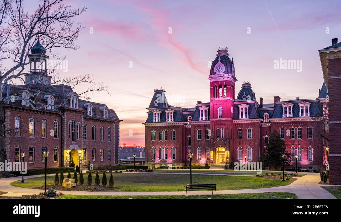 Dramatisches Bild der Woodburn Hall an der West Virginia University oder der WVU in Morgantown WV, während die Sonne hinter dem beleuchteten historischen Gebäude untergeht Stockfoto