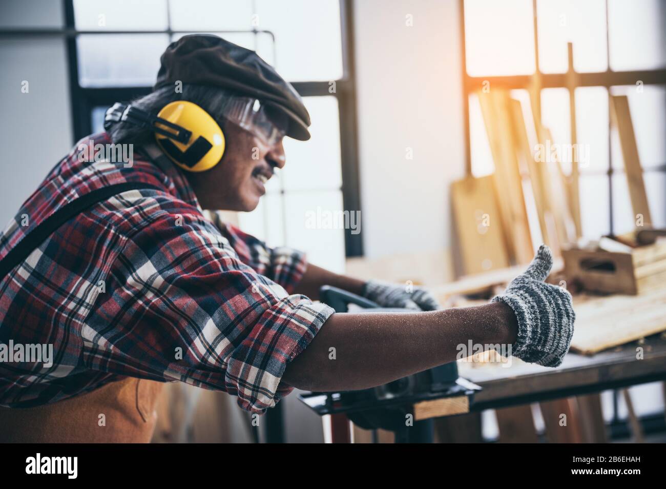 Alter Tischlermeister, der im Tischlerstudio arbeitet Stockfoto