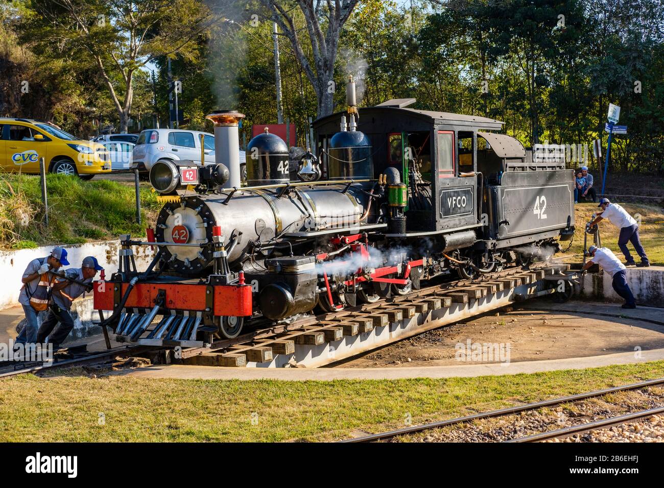 Arbeiter, die mit der Drehscheibe der Eisenbahn die Dampflok Richtung Sao Joao del Rey, Bahnhof Tiradentes, Stadt Tiradentes, Minas Gerais Brasilien drehen. Stockfoto