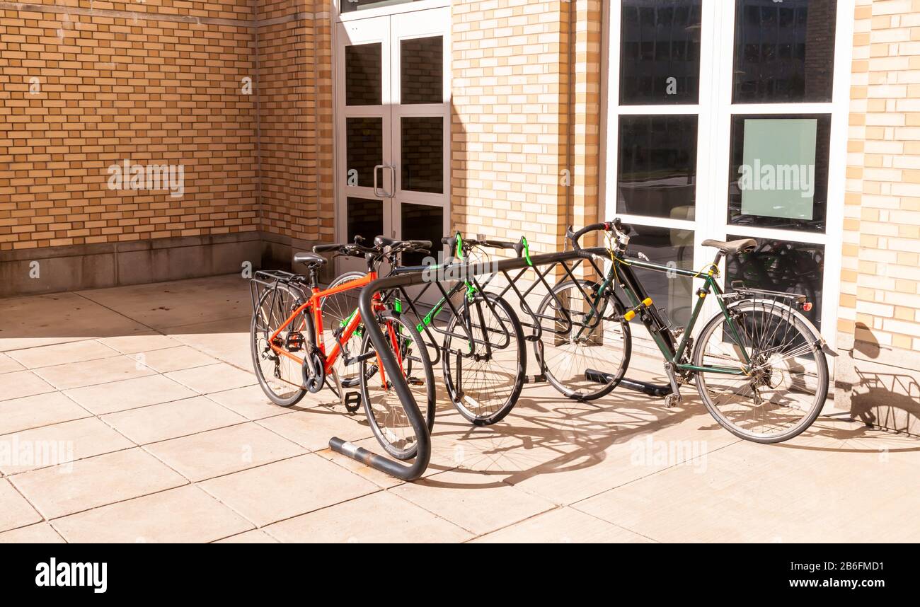 Fahrräder sind an ein Fahrradregal vor einem Gebäude auf dem Campus der Carnegie Mellon University, Pittsburgh, Pennsylvania, USA, gekettet Stockfoto