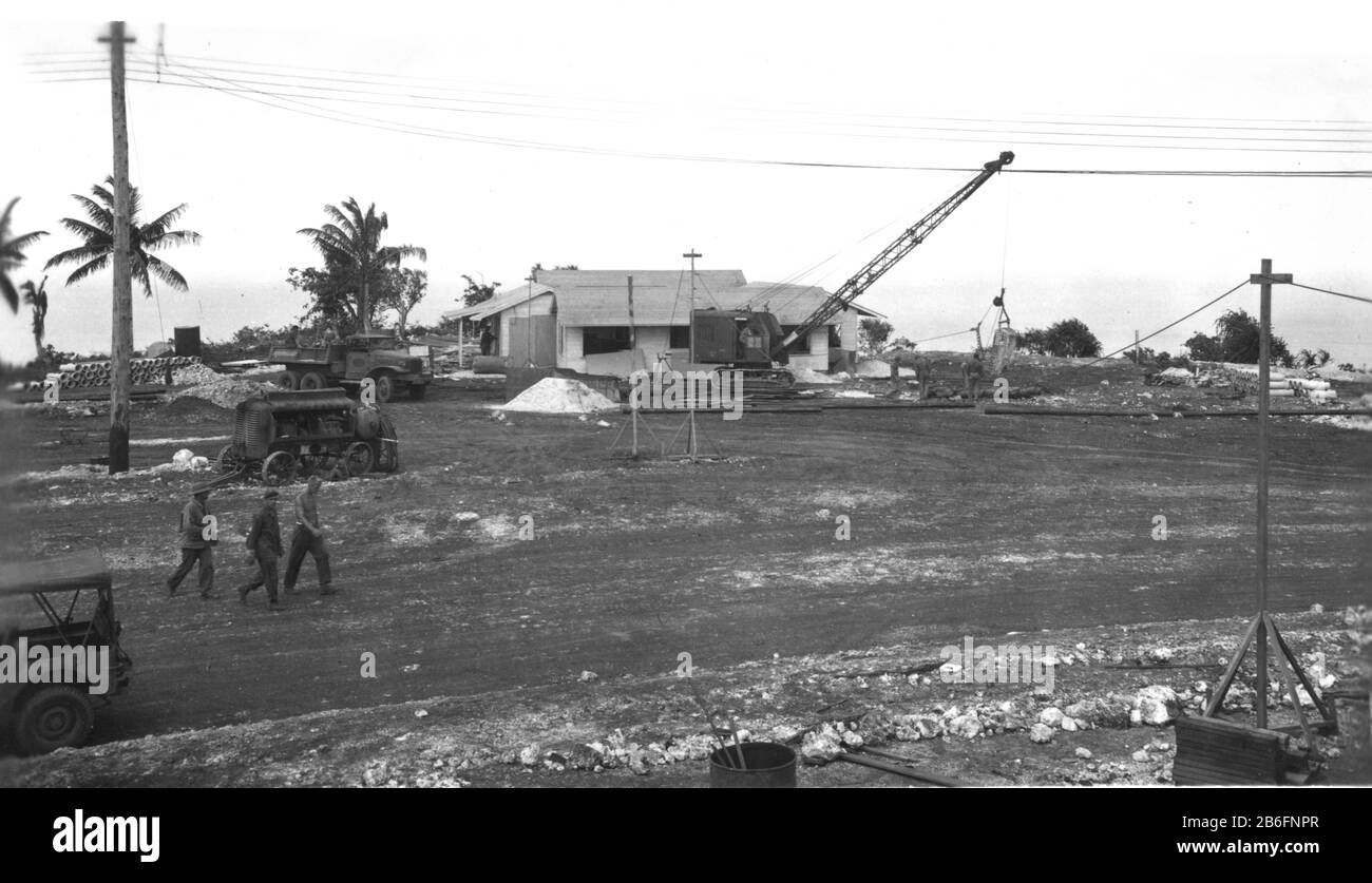 Seabees auf Guam, # 3, 22. Dezember 1944. Der Text auf diesem Foto ist: 'CINCPAC Flag Officers' Quarters # 4. Dragline Beginn Kanalaushub. Stromleitung abgeschlossen. 49. USNCB, Guam, M.I.' Beachten Sie den großen Kran, Kipper, großen Generator und die elektrischen Leitungen aufgereiht. Ein Großteil des Gebäudes ist fertig, aber es bleibt noch viel zu tun. Um meine WW II-bezogenen Bilder zu sehen, Suche: Prestor Vintage WW II Fahrzeug Stockfoto