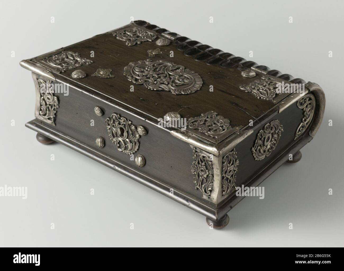 Kassette in Buchform Kassette in Buchform im vierten runden, abgeflachten Bein. Die Ecken haben silberne Beschläge im Rokoko-Motiv. Auf dem mit Floretten umgebenen Deckaufsatz. Silbernes Schloss mit Schalenmotiv unter anderem auf der Schlossplatte. Die hintere Kassette ist wie ein Buch durchsetzt. Schlüssel ontbreekt. Hersteller : Meubelhersteller: Anonymer Standort Herstellung: Indonesien Datum: 1.750 - 174 Material: Ebenholz Silber Kupfer Technik: Schneiden / Laden / Engras (Ausklinken) Abmessungen: H 7 cm. B × 24 cm. D × 17 cm. Betrifft: Buch-Fantasieornament, wenn: 1.750 - 1775 Stockfoto