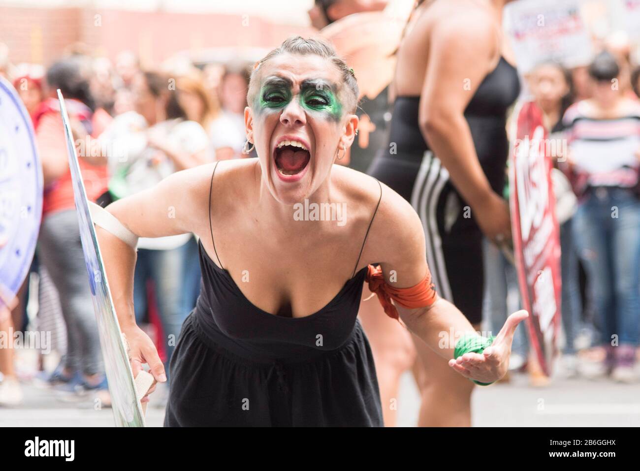 CABA, Buenos Aires/Argentinien; 9. März 2020: Internationaler Frauentag. Junge Frau, schreiend, mit einem grünen und einem orangefarbenen symbolischen Taschentuch: Le Stockfoto