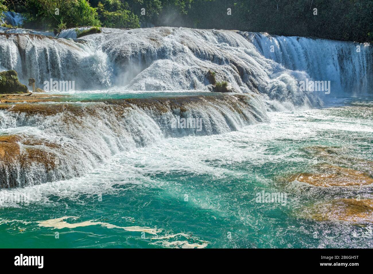 Das türkisfarbene Wasser des Agua Azul Wasserfalls, der mit Gewalt abfließt, erzeugt im Regenwald von Chiapas in der Nähe von Palenque, Mexiko viel Spray in der Luft. Stockfoto