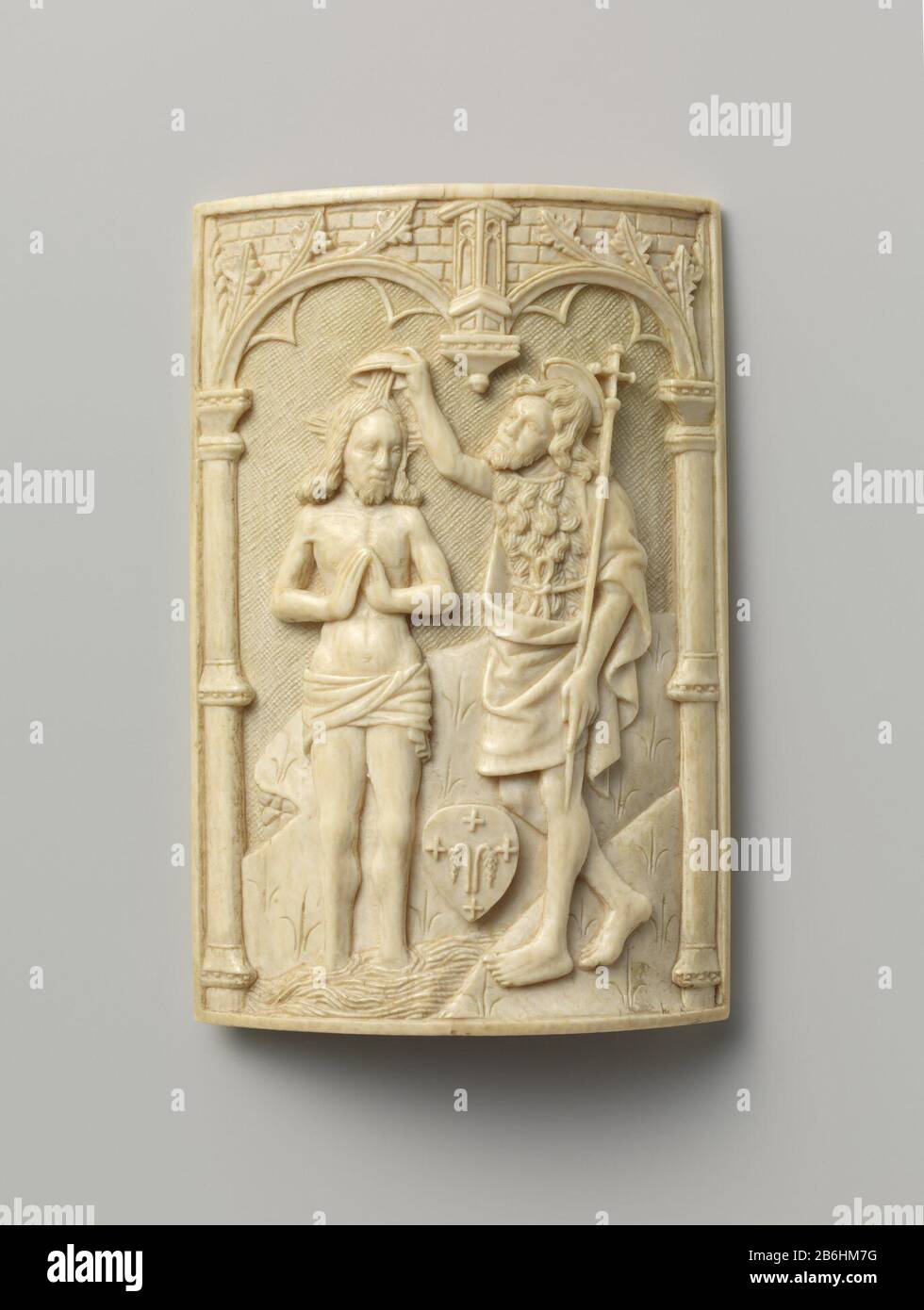 Der Sprung in den Jordan (Pax) Paxtafel mit der Taufe im Jordan Een gebogen, rechthoekig ivoren plaatje (deel van een olifantsstand) dat aan de buitenzijde ist voorzien van een voorstelling van de Doop in de Jordaan onder een gotische Arkade, steunend op e ziltes, jiltes, Die aan weerszijden de voorstelling begrenzen. TUSUS Johannes de Doper en Jezus is een niet geidentificeerd wappenschild, dat mogelijk behoord heeft een broederschap of klooster. Hersteller : Ivoorsnijder: AnoniemPlaats Herstellung: Zuidelijke Nederlanden dating: CA. 1500 Physische Kenmerken: Gesneden ivoor Material: Ivoor Stockfoto