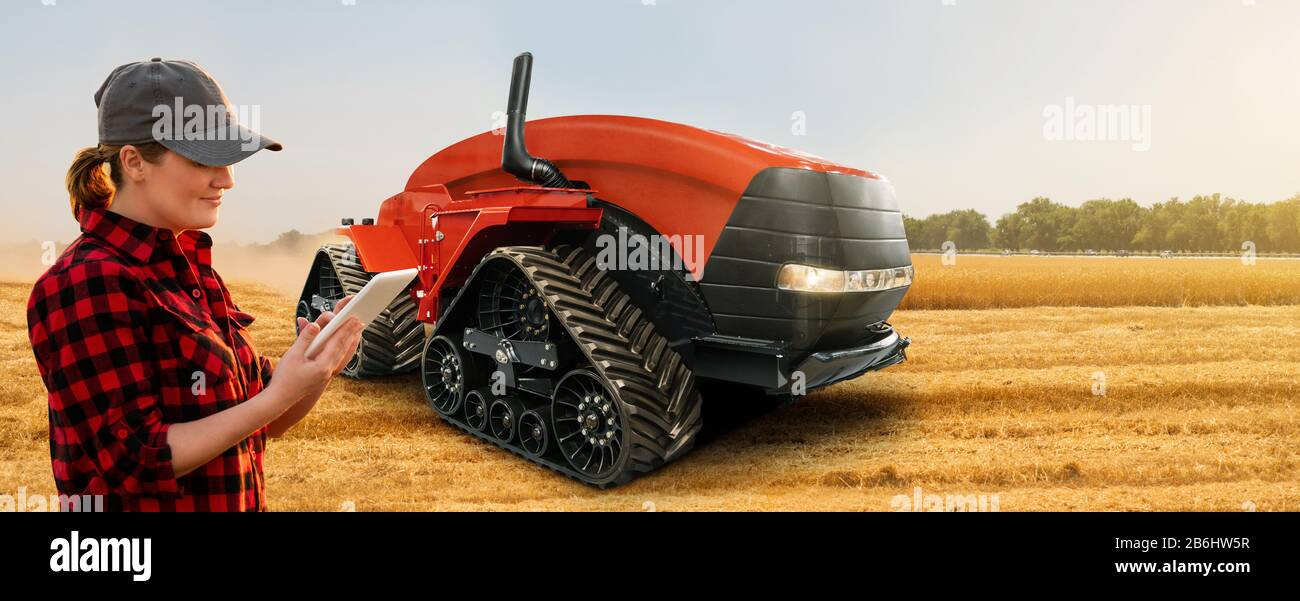 Farmer mit digitaler Tablette steuert autonome Traktoren auf einer intelligenten Farm Stockfoto