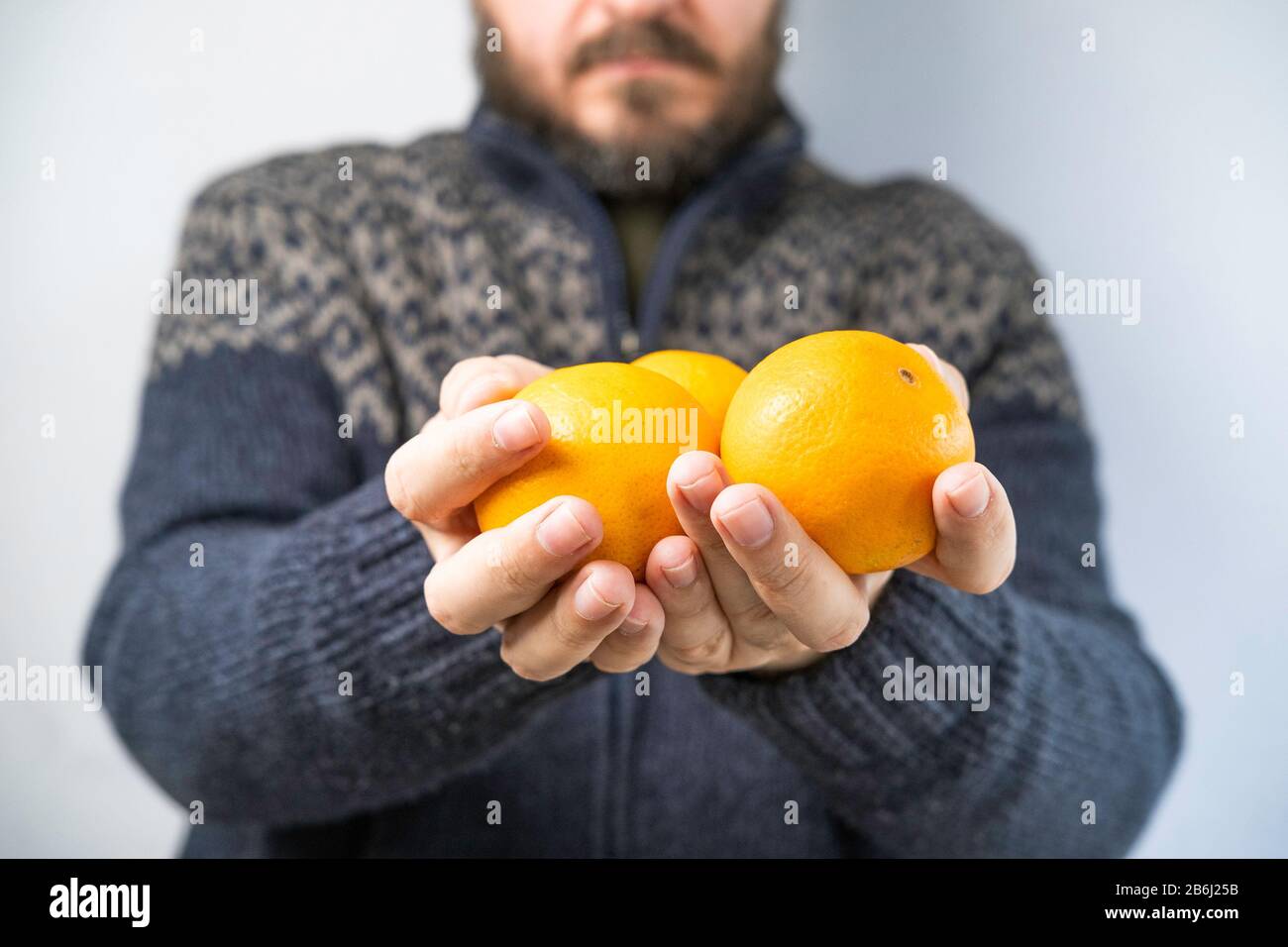 Mann im Pullover mit Orange, Handdetails, verschwommenem Hintergrund, geringer Verschuldung des Feldes Stockfoto