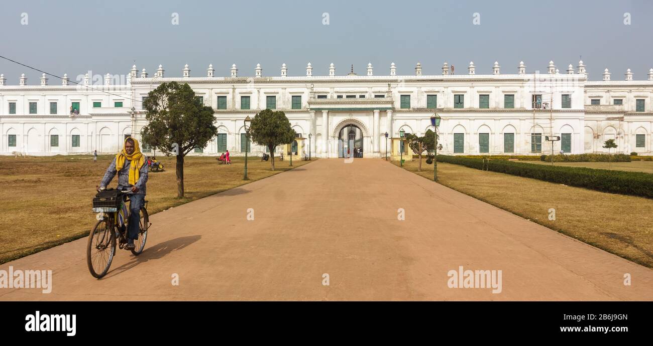 Murshidabad, Westbengalen/Indien - Januar 15 2018: Ein Mann auf dem Fahrrad fährt auf der breiten Straße, die zum Nizamat Imambara führt. Stockfoto