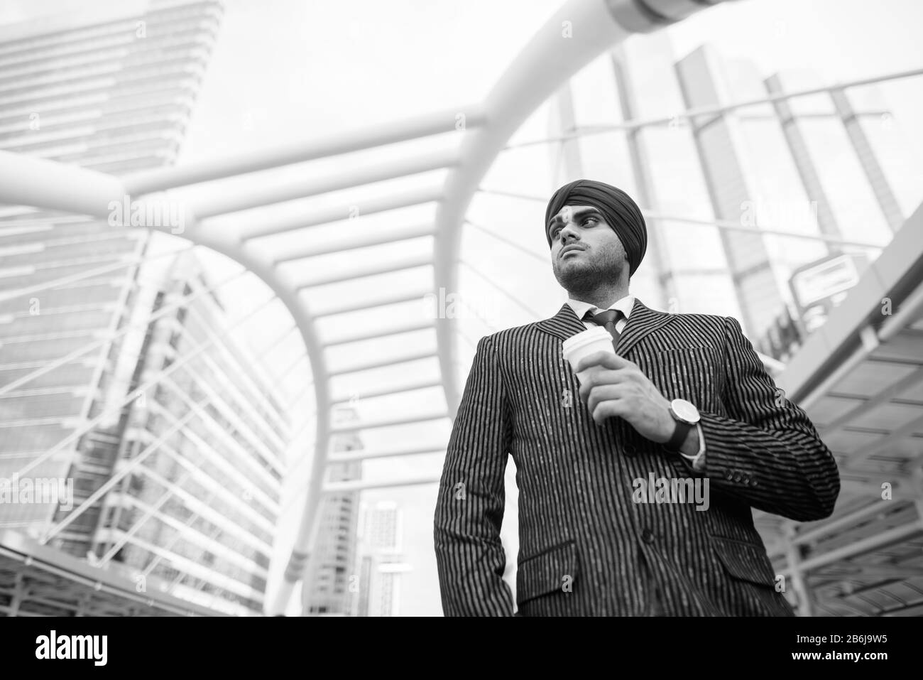 Junger gutaussehender indischer Sikh-Geschäftsmann, der Turban in der Stadt trägt Stockfoto