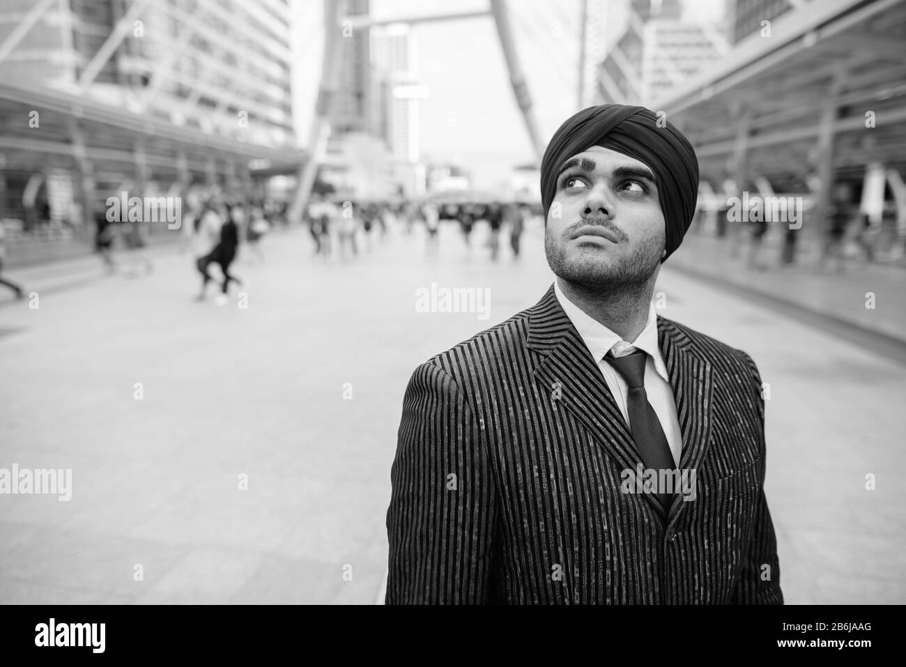 Junger gutaussehender indischer Sikh-Geschäftsmann, der Turban in der Stadt trägt Stockfoto