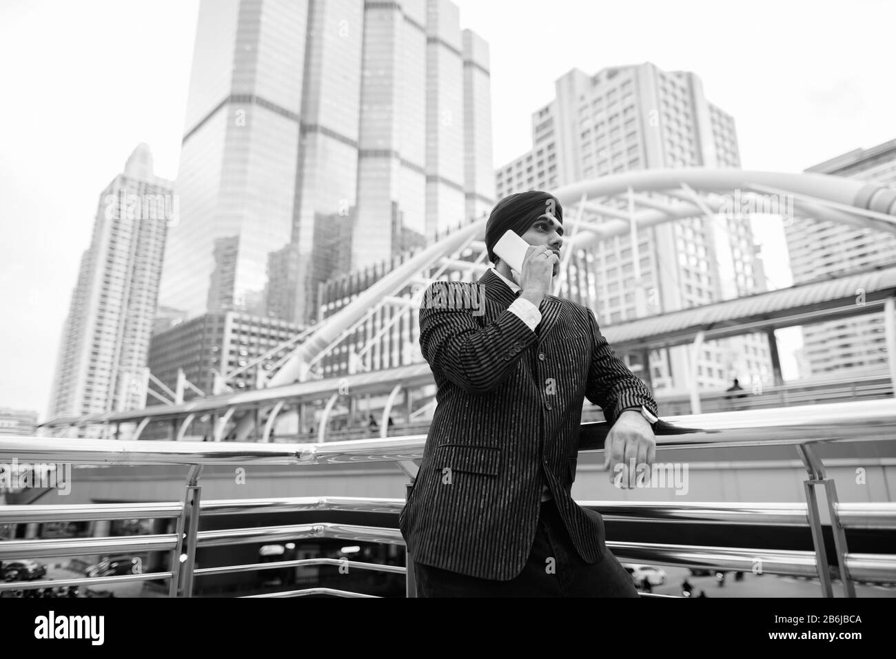 Junger, gutaussehender indischer Sikh-Geschäftsmann gegen den Blick auf die Stadt Stockfoto