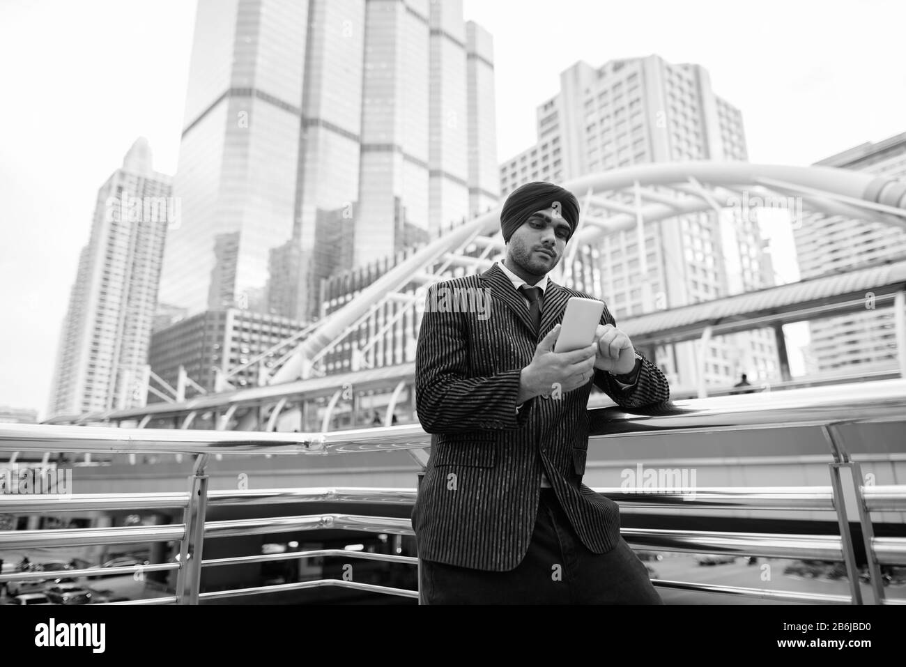 Junger, gutaussehender indischer Sikh-Geschäftsmann gegen den Blick auf die Stadt Stockfoto