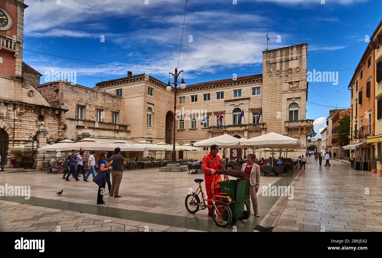 Zadar, Provinz Dalmatien, Kroatien, Narodni trg ist das Zentrum des öffentlichen Lebens in Zadar von der Renaissance bis heute. Auf dem Gelände des großen Platzes, der Platea magna, wurden im frühen Mittelalter die Grundmauern städtischer Institutionen gelegt. Danach wurden hier die Stadtloge und die Kirche St. Peter der neue errichtet. Sie wurden während der Herrschaft Venetiens im 15. Jahrhundert von den Behörden zerstört. Im 16. Jahrhundert wurde das Gebäude der Stadtwache (Gradska straža) mit dem Uhrturm der Stadt erbaut. Stockfoto