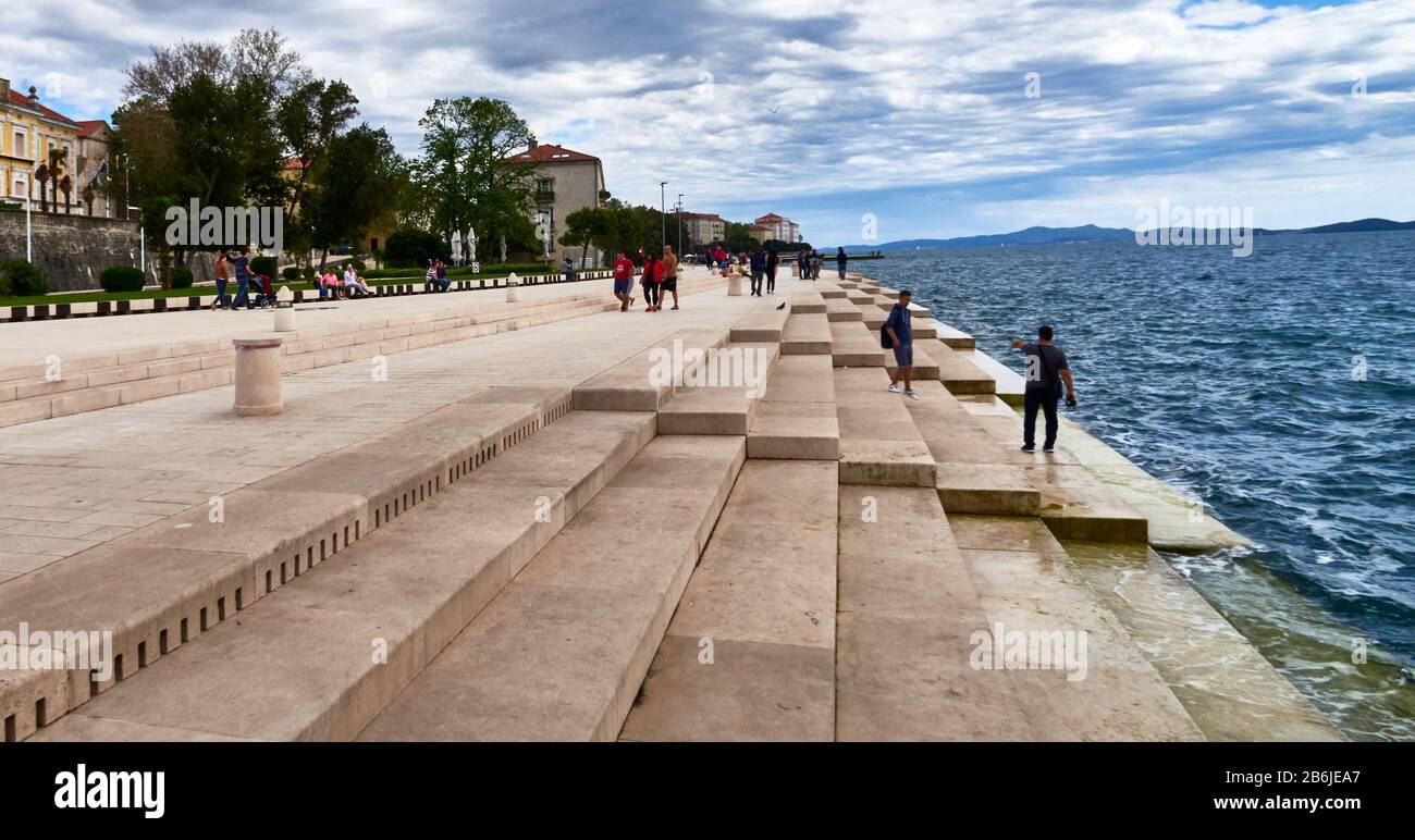 Zadar, Provinz Dalmatien, Kroatien, in Zadar Riva, ist die See-Orgel ein architektonisches Klangkunstobjekt, ein experimentelles Musikinstrument, das Musik über Meereswellen und Röhren spielt, die sich unter einer Reihe großer Marmorstufen befinden. Die Wellen interagieren mit der Orgel, um etwas zufällige, aber harmonische Töne zu erzeugen. Von Nikola Baši? Kroatischer Architekt Stockfoto