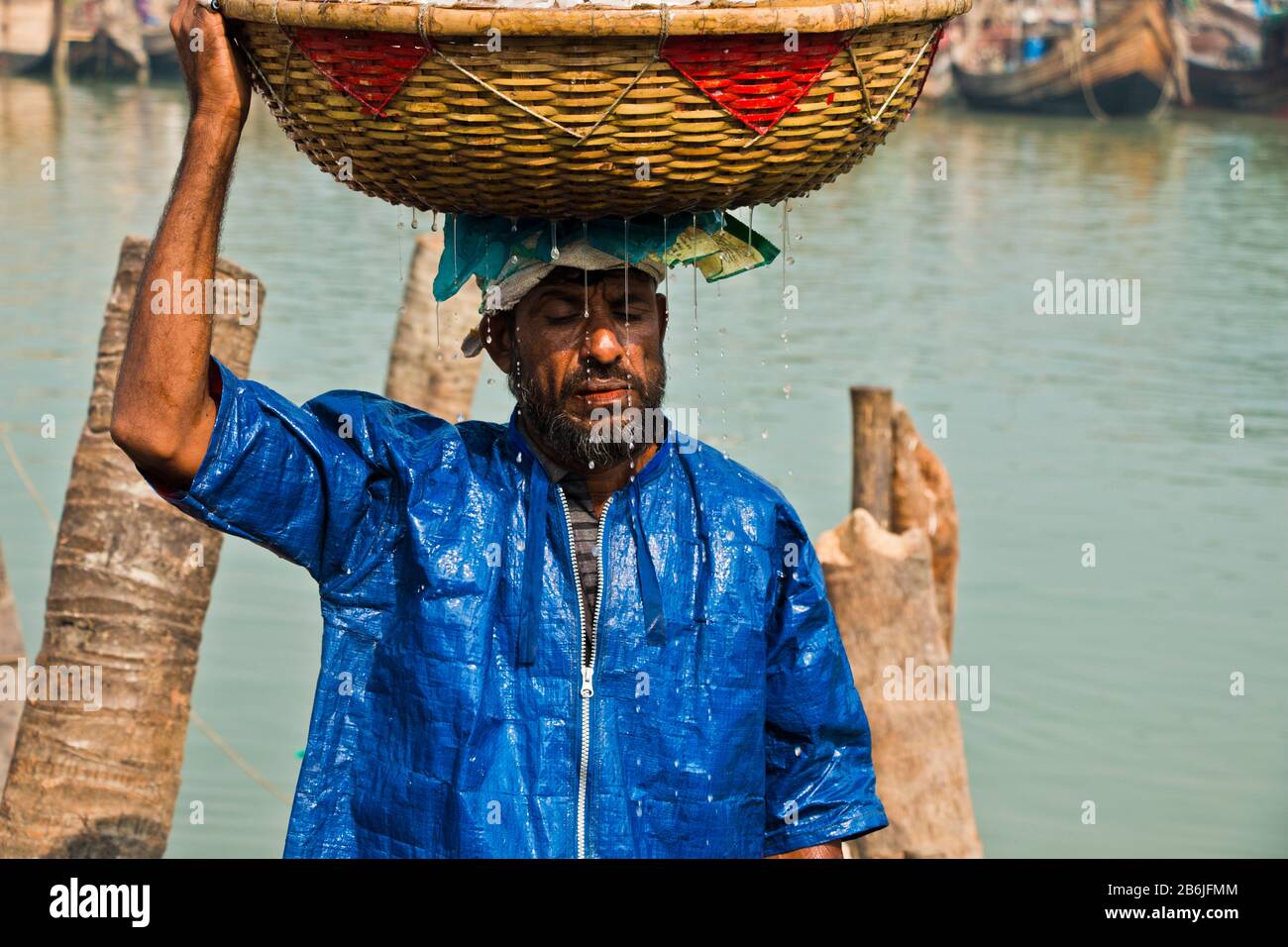 Labore entladen verschiedene Fischarten aus dem Fischerhafen. Fisch ist ein großes Mittel zur Bekämpfung der Ernährungsunsicherheit und des Klimawandels in Bangladesch. Stockfoto