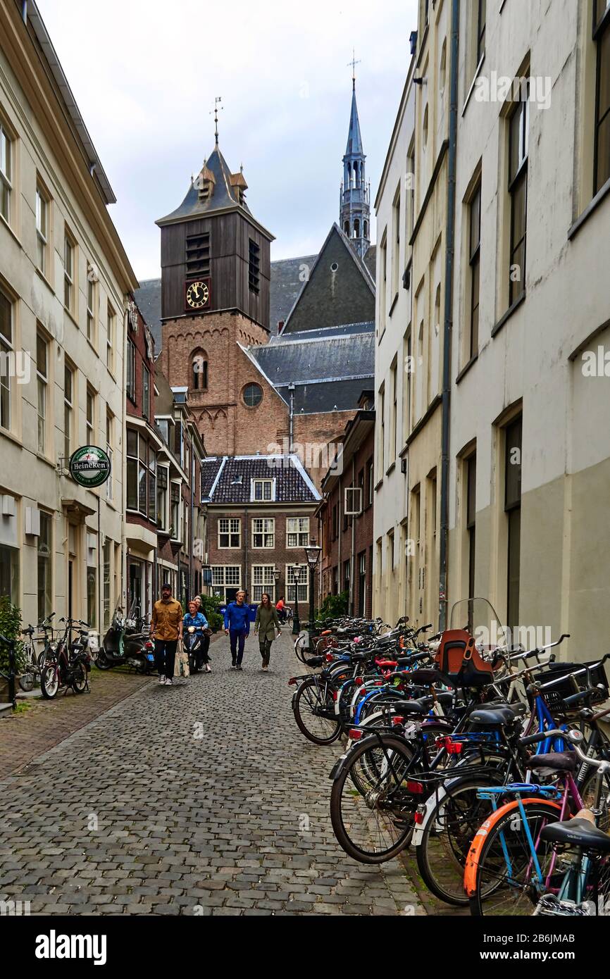 Stadt Leiden, Provinzland Südholland, Niederlande, Europa - : Blick auf die Hooglandse Kerk Kirche und die typische enge Straße, geparkte Fahrräder neben den Häusern und Handelsschilder an den Geschäften. Die zwischen 1391 und 1415 erbaute Hooglandse Kerk Kirche enthält gotische Elemente. Es war zunächst eine Römisch-Katholische Kirche und wurde 1572 eine evangelische Kirche Stockfoto