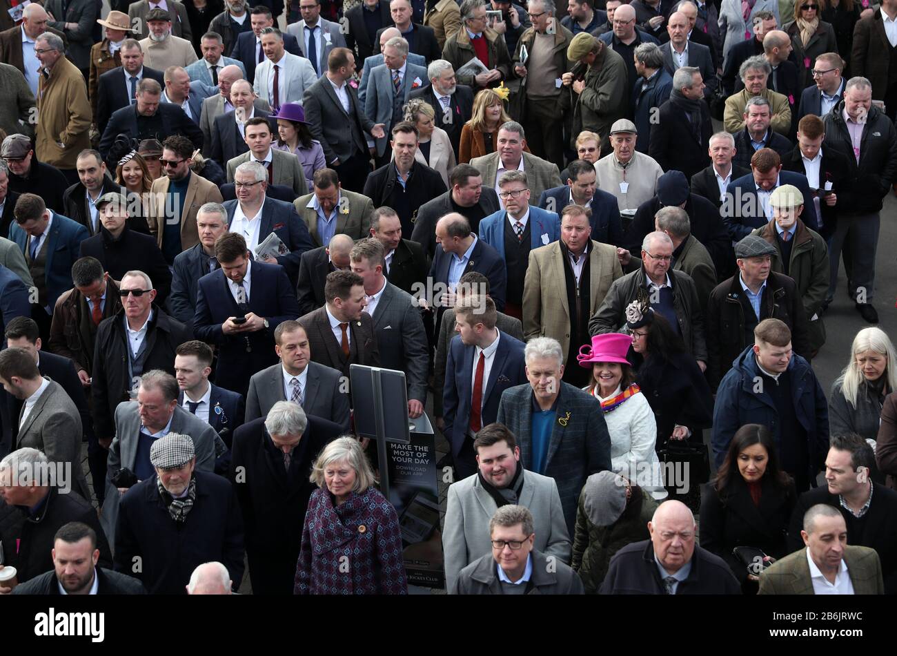 Am zweiten Tag des Cheltenham Festivals auf der Pferderennbahn Cheltenham warten Menschenmassen vor dem Haupteingang. Stockfoto