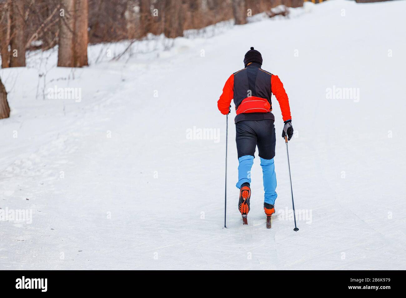 Mann trägt Sportuniform auf dem Skilanglauf in einem Stadtpark, gesundes Lifestyle-Konzept Stockfoto