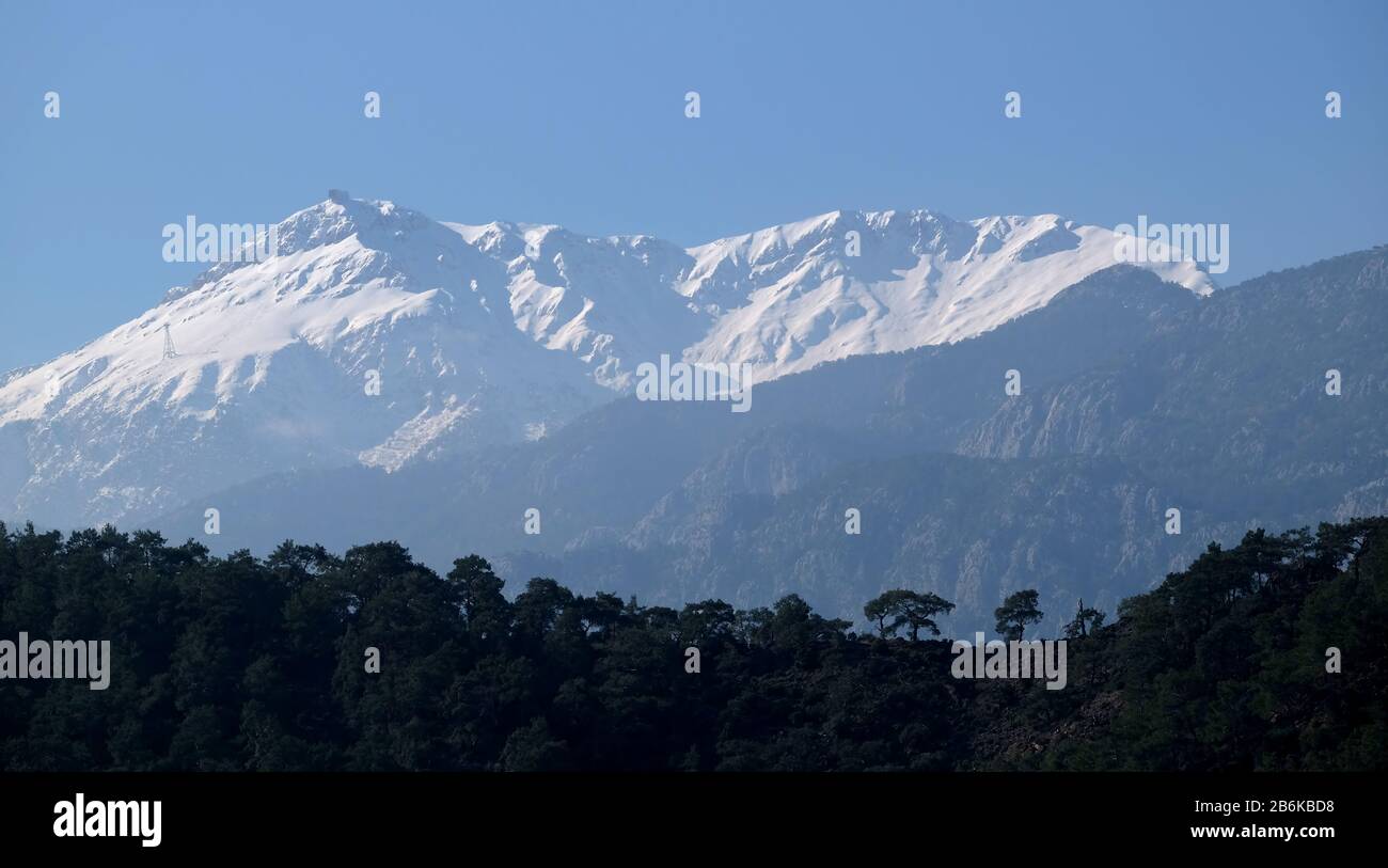 Panoramalandschaft mit türkischen Bergen unterschiedlicher Höhe, Bergkiefern an den hängen und Schnee auf hohen Gipfeln bei weitem Stockfoto