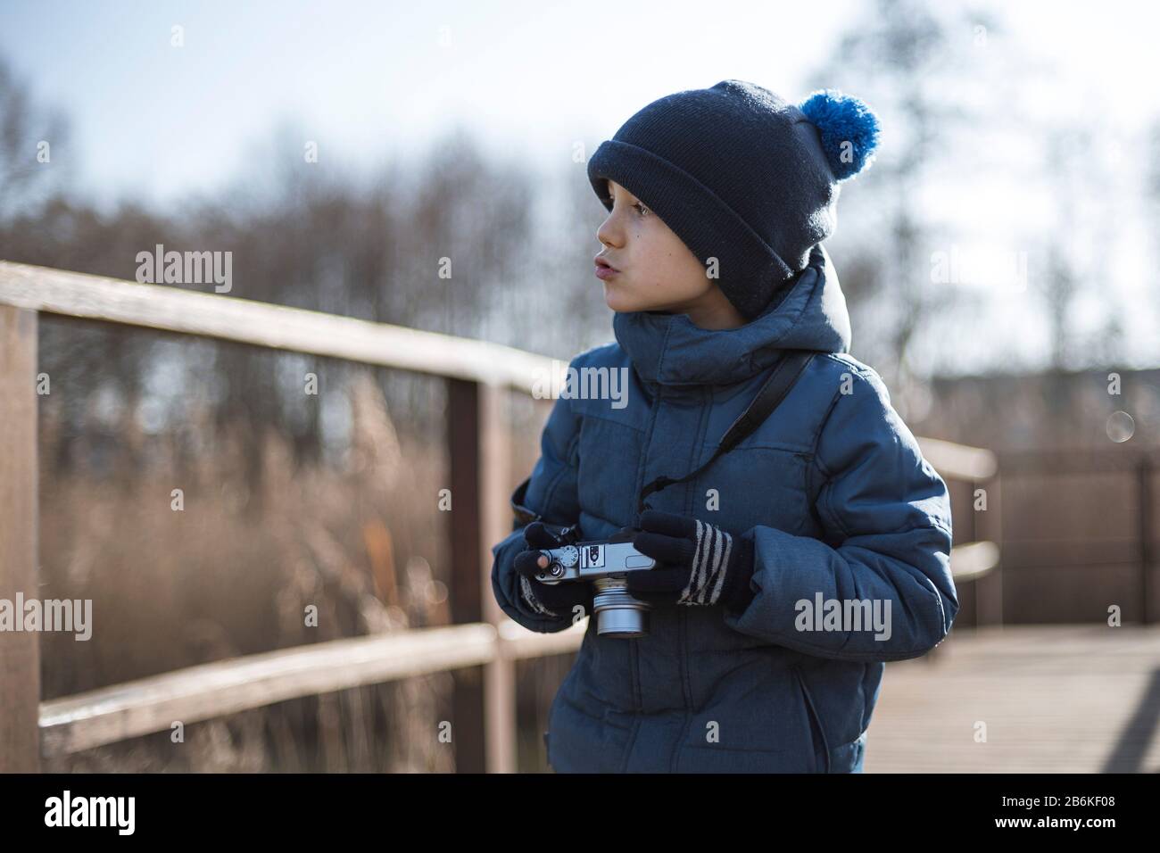 Kleiner Junge mit Kamera fotografiert im Park Stockfoto