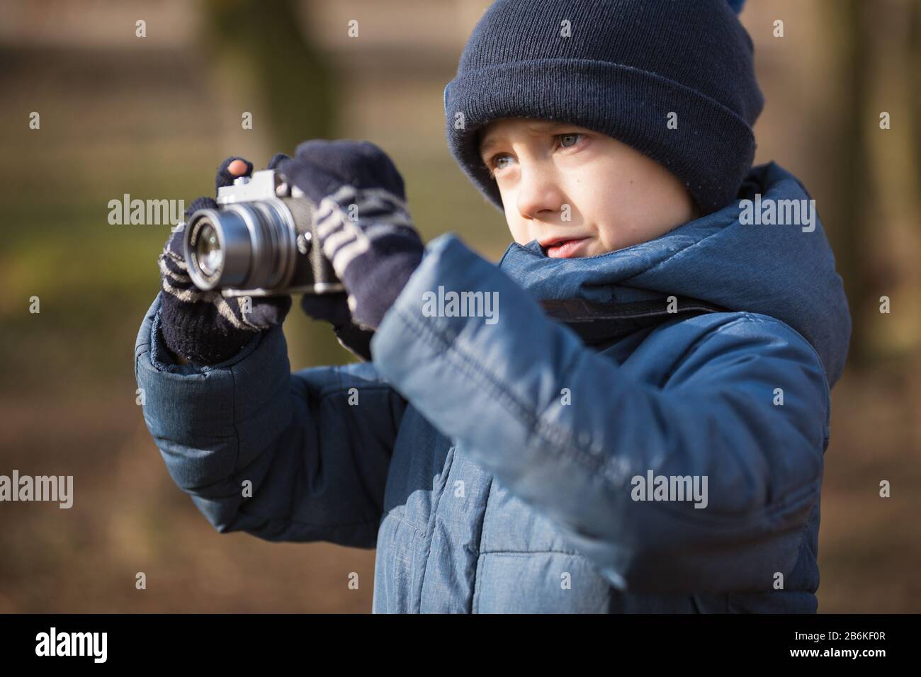 Kleiner Junge mit Kamera fotografiert im Park Stockfoto
