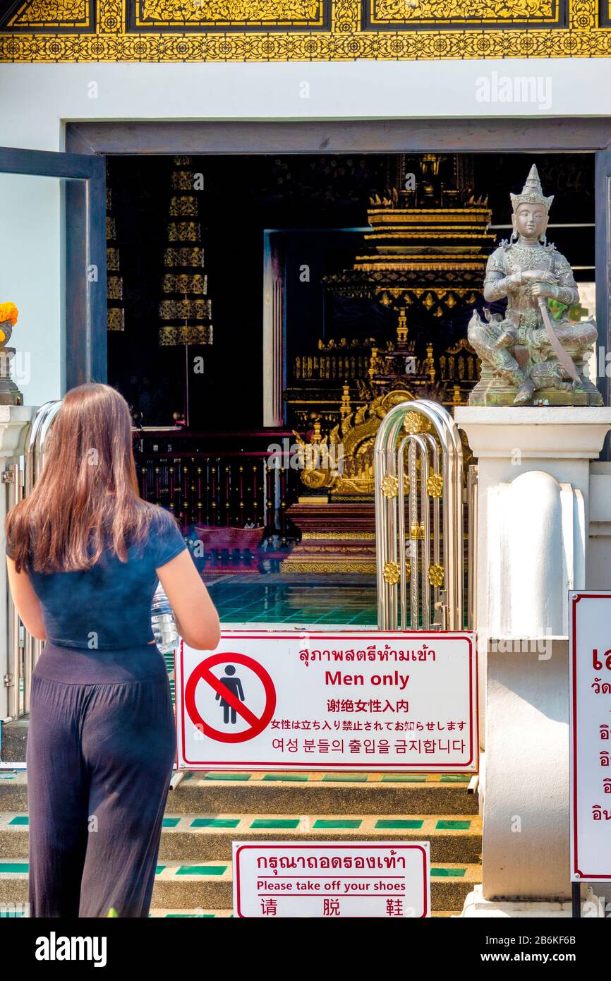 Frau, die vor Sao Inthakin im Wat Chedi Luang Tempel, Chiang Mai, Thailand, wartet Stockfoto