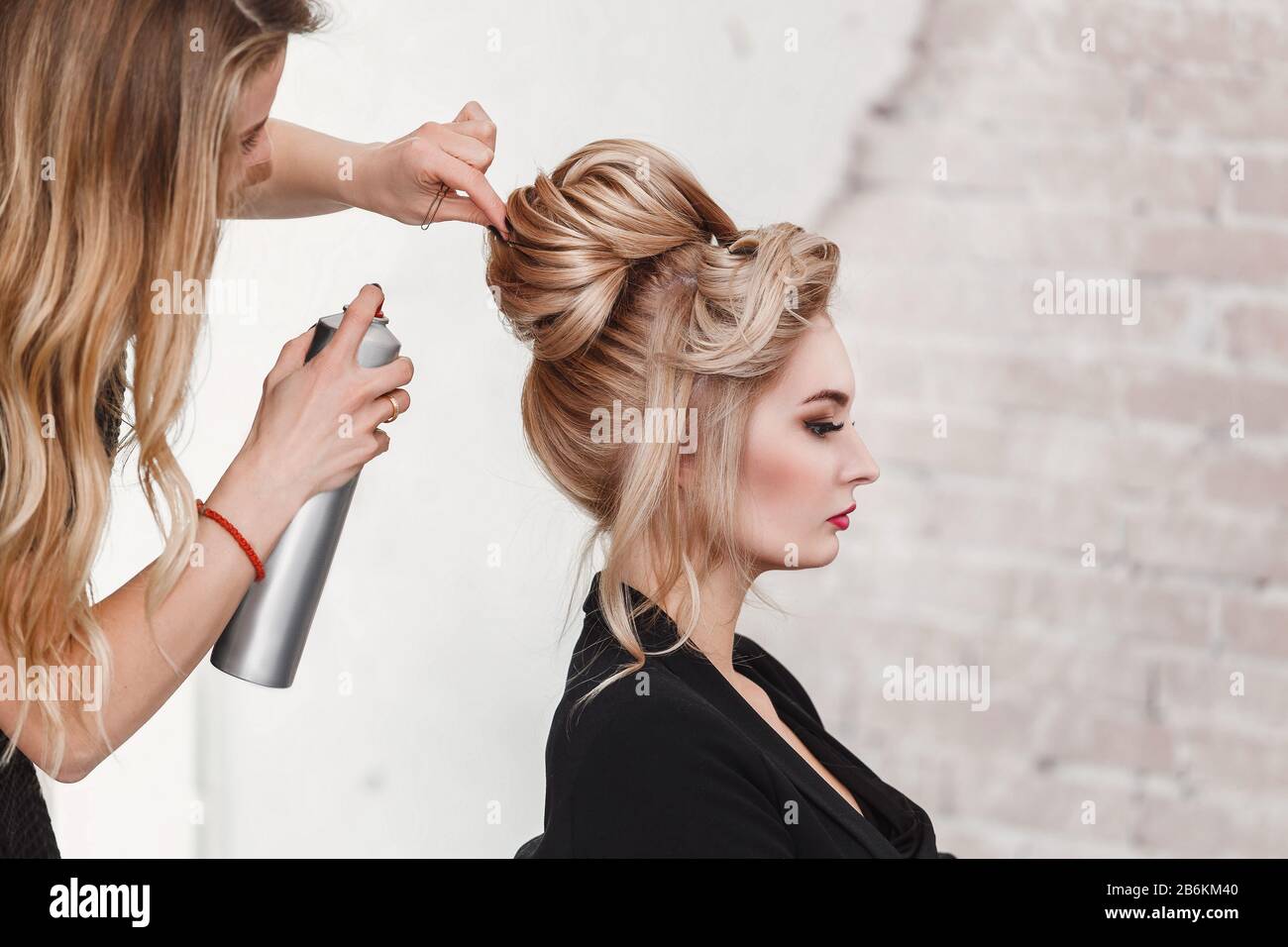 Professioneller Friseur mit Haarspray auf die Haare der Geschäftsfrau des  Kunden im Schönheitssalon Stockfotografie - Alamy