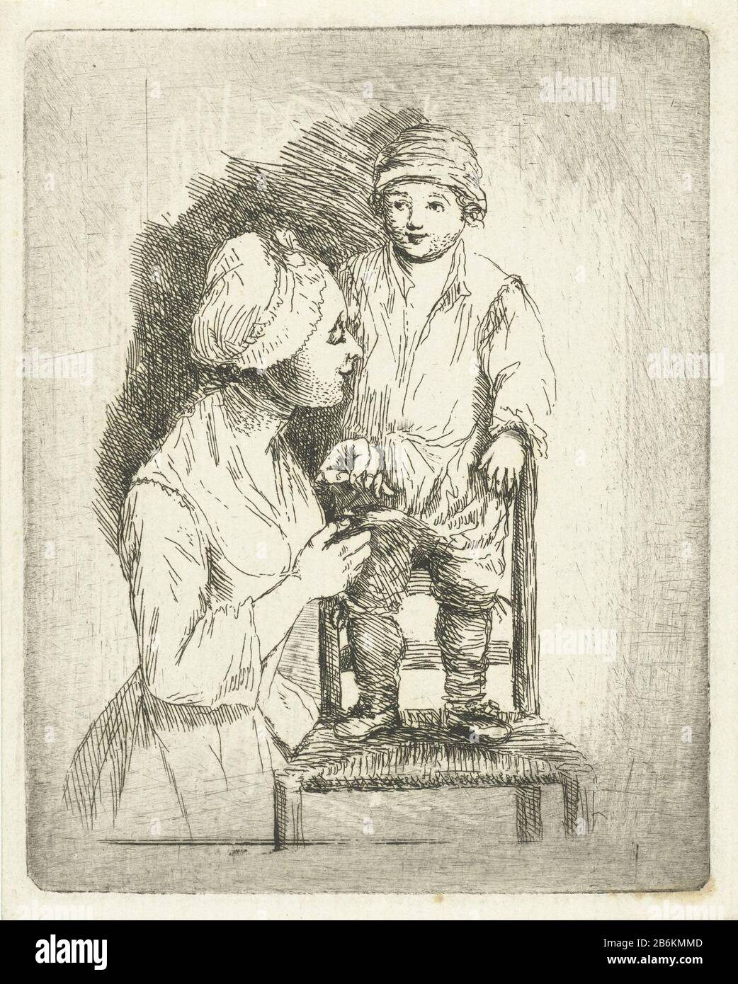 Eine Mutter legt einen Knopf auf die Hose ihres Sohnes, EINES Jungen, der  auf einem Stuhl steht. Seine Mutter ist mit Nadel und Faden beschäftigt, um  seinen broek zu drehen. Hersteller :