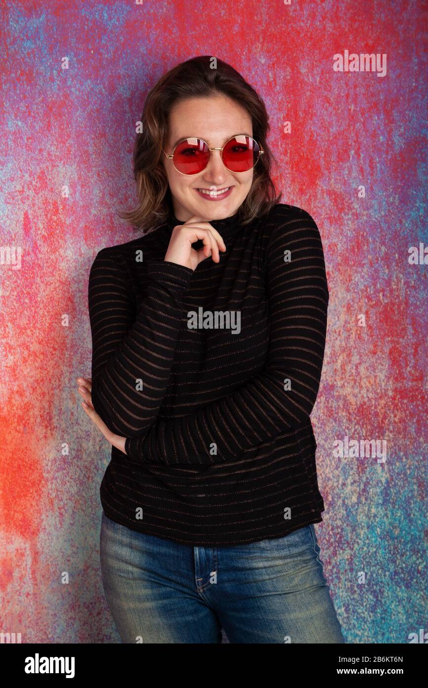 Porträt einer zwanzigjährigen Frau, die rote Brille und einen Blick durch die Spitze trägt Stockfoto
