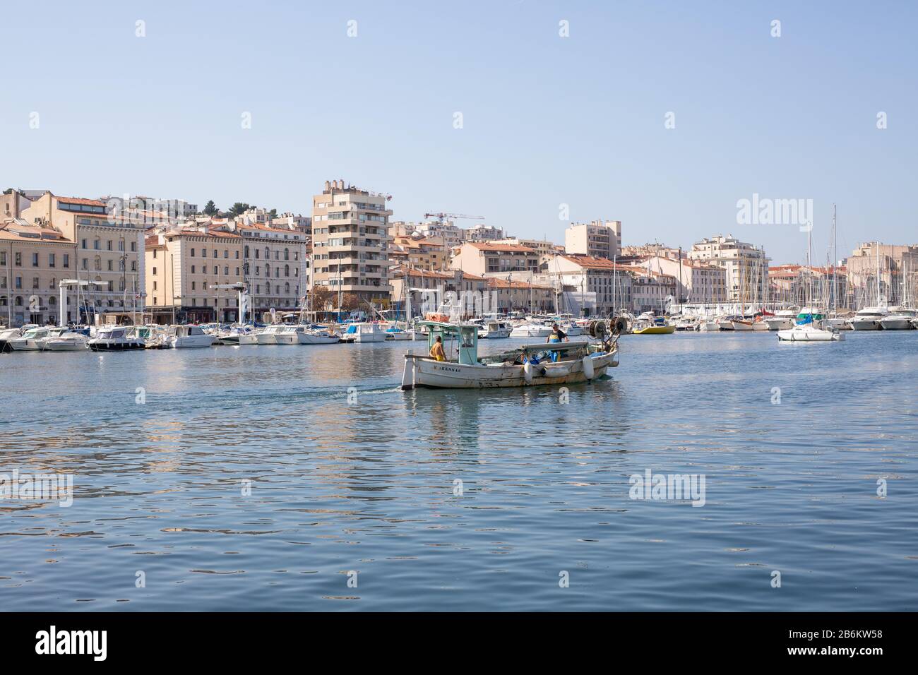 Ein kleines Fischerboot, das den Alten Hafen von Marseille, Frankreich, verlässt. Stockfoto
