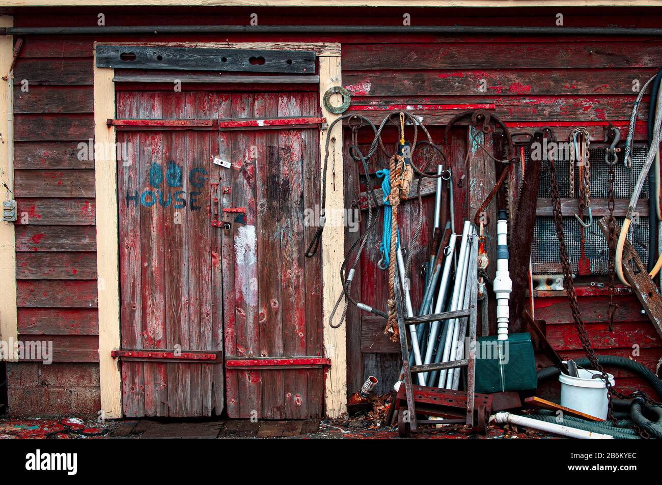 Ein verwitterter und verfallender Arbeitsschack auf den Docks im Hafen von Gloucester steht mit maroden Holzschindeln und einer Fülle von Teilen, Seilen und Vintage Stockfoto