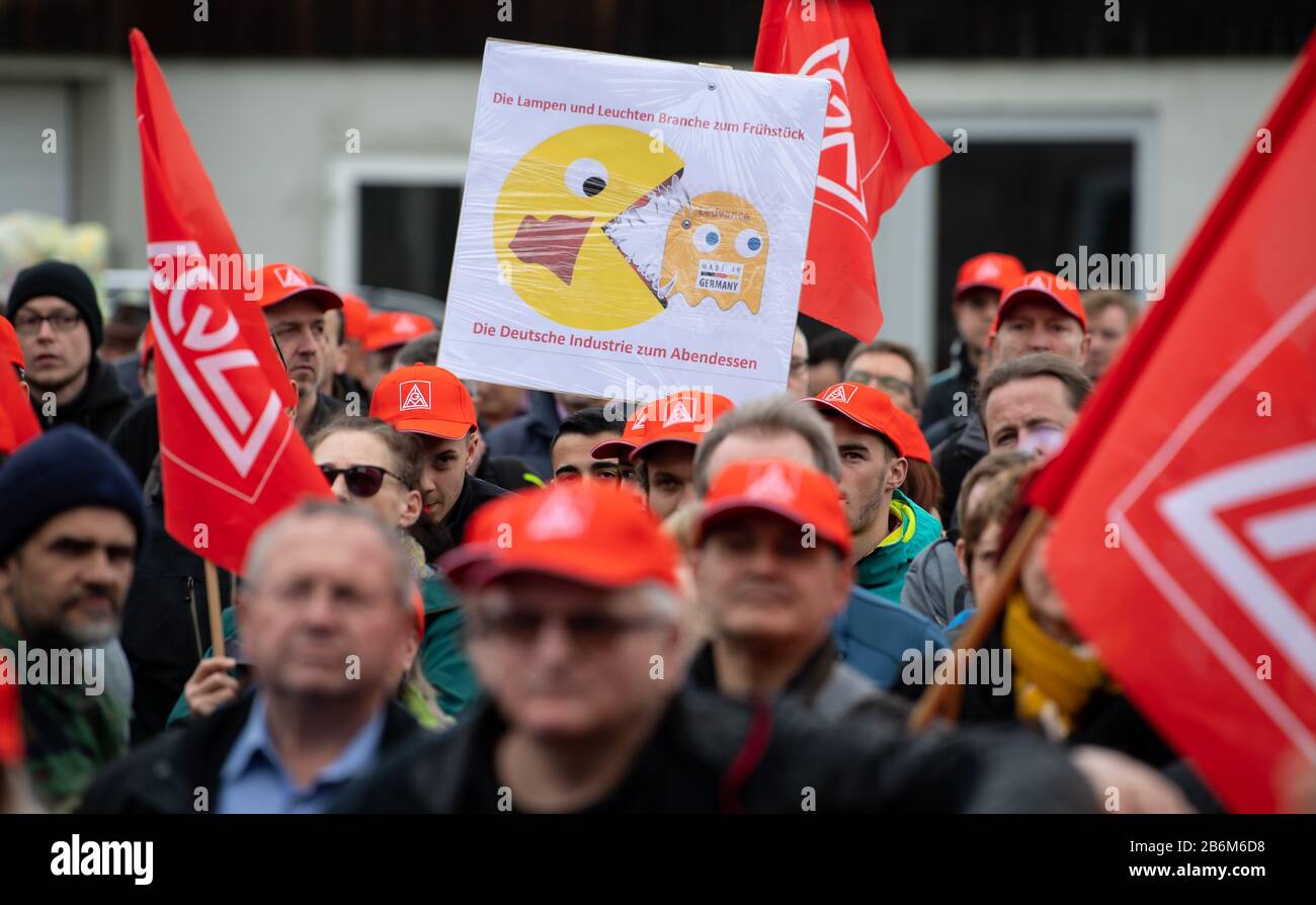 11. März 2020, Bayern, Augsburg: Mitarbeiter des Beleuchtungsherstellers Ledvance nehmen an einer Kundgebung im Werk in Augsburg Teil und halten ein Plakat mit den Worten "Die Lampen- und Beleuchtungsindustrie zum Frühstück, die deutsche Industrie zum Abendessen" auf. Der Beleuchtungshersteller Ledvance will mit rund 360 Mitarbeitern sein größtes deutsches Werk in Eichstätt schließen. Foto: Sven Hoppe / dpa Stockfoto