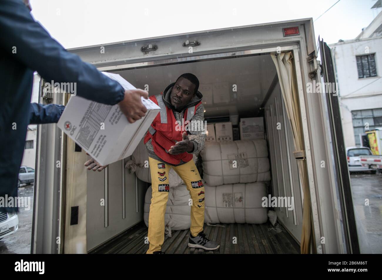 Tripolis, Libyen. März 2020. Ein libyscher Arbeiter des Roten Halbmonds (LRC) überträgt am 10. März 2020 internationale Hilfe des Roten Kreuzes in der LRC-Zentrale in Tripolis, Libyen. Kredit: Amru Salahuddien/Xinhua/Alamy Live News Stockfoto