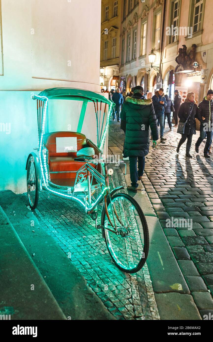 02. DEZEMBER 2017, PRAG, TSCHECHIEN: Fahrradrickshaw mit Lichtern auf einer belebten Straße in der Stadt, die auf Kunden wartet Stockfoto