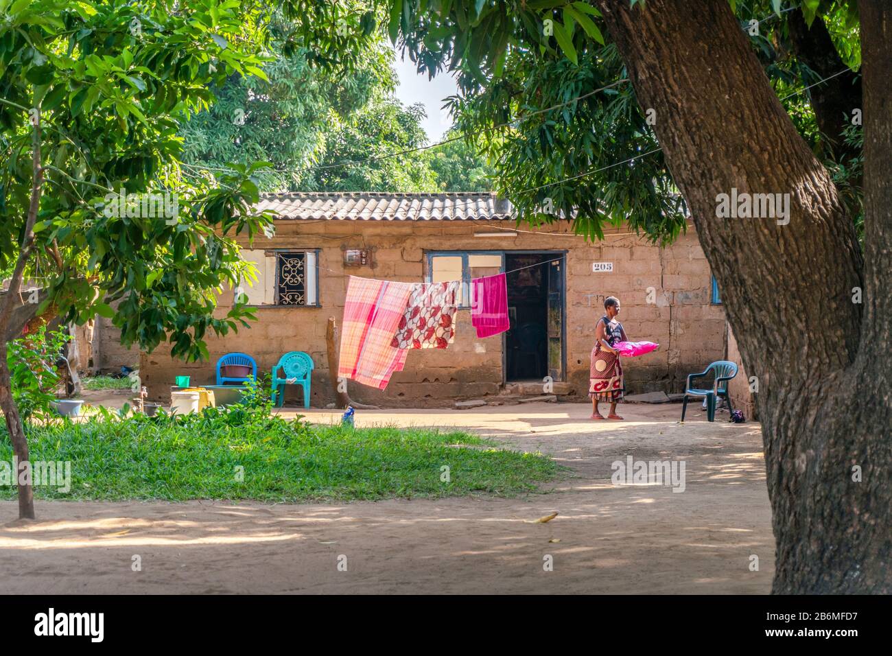 Matola, Mosambik - 23. Mai 2019: Afrikanerin macht tägliche Aufgaben vor ihrem einfachen, sauberen Haus Stockfoto
