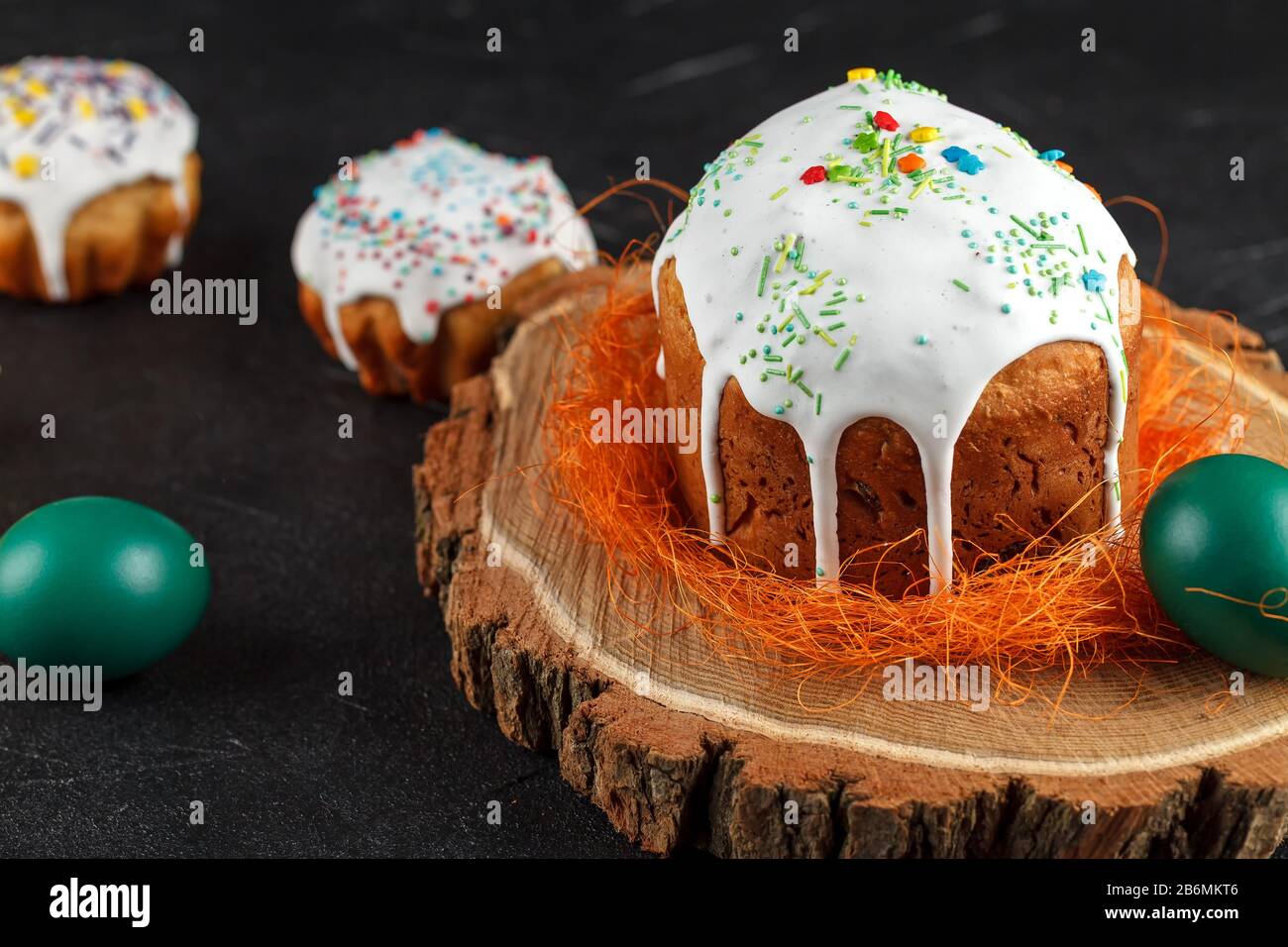 Frischer Osterkuchen, zu Hause gebacken und mit süßem Icing dekoriert. Farbige gekochte Eier liegen als Bestandteil des Osterfeiertags auf dem Tisch. Künstlich Stockfoto