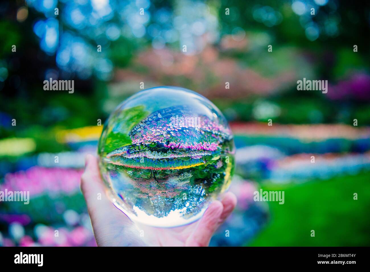 Hand mit Kristallkugel im formellen Garten, Butchart Gardens, Vancouver Island, British Columbia, Kanada Stockfoto