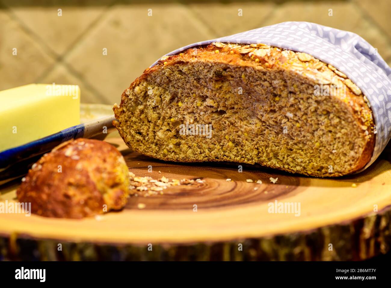 Frisch gebackenes rundes Laib Vollkornbrot mit Butter Stockfoto